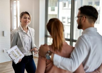 Real estate agent talking to a couple interested in buying new h